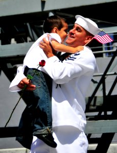 US Navy 100412-N-4774B-518 A Sailor assigned to the guided-missile cruiser USS Bunker Hill (CG 52) greets his son after returning from a three-month deployment photo