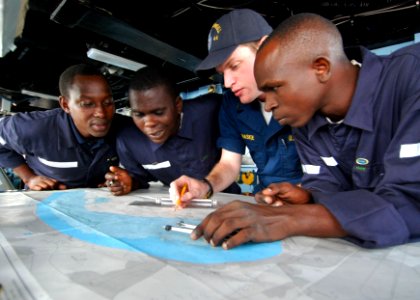 US Navy 100412-N-6138K-381 Ensign Michael Manaskie shows APS students how to use a nautical navigation chart aboard the amphibious dock landing ship USS Gunston Hall (LSD 44)