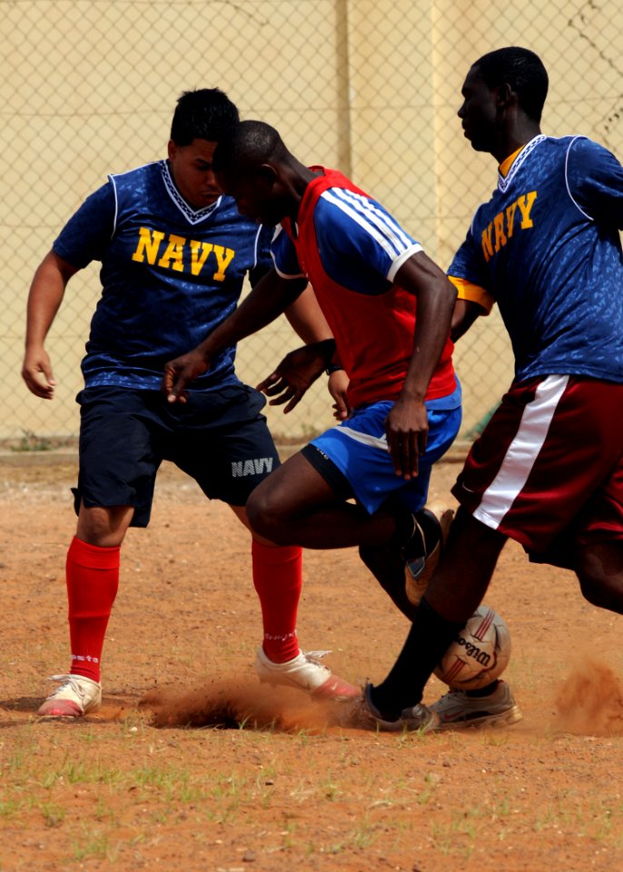 US Navy 100412-N-6676S-083 Information Systems Technician 2nd Class Mark Cervantes nd Boatswain's Mate Seaman Jean Petitfrere try to strip the ball from a Senegalese navy soccer team player during a soccer match