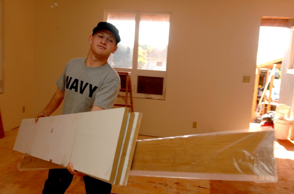 US Navy 100409-N-0535P-037 viation Structural Mechanic 3rd Class Ryan Snay moves siding and works with local volunteers during a Habitat for Humanity home-build in Hanapepe, Kauai