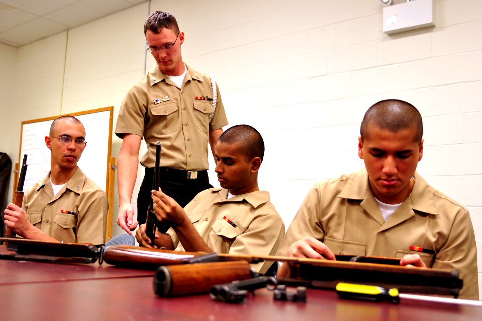 US Navy 100414-N-8132M-035 Seaman Eric Hunt shows U.S. Navy Ceremonial Guard trainees how to disassemble their rifles