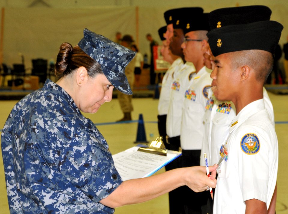 US Navy 100410-N-8848T-846 Senior Chief Yeoman Patricia Arnold measures the ribbons of a Navy Junior ROTC cadet from Centennial High School