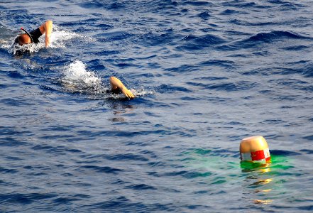 US Navy 100409-N-4774B-065 Search and Rescue swimmers from the guided-missile cruiser USS Bunker Hill (CG 52) recover an exercise torpedo during a test of the torpedo launch system