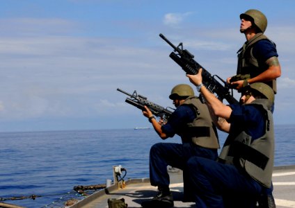 US Navy 100414-N-1675O-073 Gunner's Mate 3rd Class Joshua Pacheco oversees Gunner's Mate 3rd Class Don Flores and Fire Controlman 3rd Class Ivan Galvez as they fire M206 grenade launchers aboard the U.S. 7th Fleet command ship