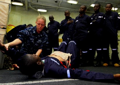 US Navy 100412-N-6138K-315 Hospital Corpsman 2nd Class Jessica Toothe demonstrates how to dress an abdominal wound to a group of embarked Sailors from Gambia, Liberia, Senegal, Sierra Leone, Tanzania, and Togo