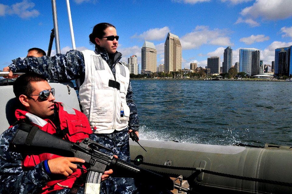 US Navy 100412-N-4774B-255 Sailors assigned to the guided-missile cruiser USS Bunker Hill (CG 52) ride a rigid-hull inflatable boat past downtown San Diego while returning home from a three-month deployment