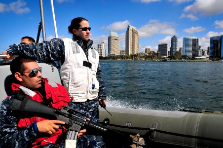 US Navy 100412-N-4774B-255 Sailors assigned to the guided-missile cruiser USS Bunker Hill (CG 52) ride a rigid-hull inflatable boat past downtown San Diego while returning home from a three-month deployment