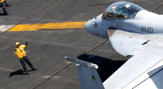 US Navy 100415-N-4236E-274 A Sailor directs an F-A-18F Super Hornet assigned to Jolly Rogers of strike fighter squadron (VFA) 103 across the flight deck of the aircraft carrier USS Dwight D. Eisenhower (CVN 69)
