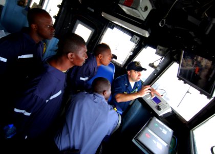 US Navy 100412-N-6138K-395 Ensign Matthew Sweet shows Tanzanian and Togolese Sailors the ship's security camera monitor aboard USS Gunston Hall (LSD 44)