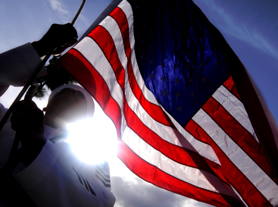 US Navy 100415-N-7586L-257 Culinary Specialist 1st Class Arnel Ortega, assigned to Joint Base Pearl Harbor-Hickam raises the National Ensign