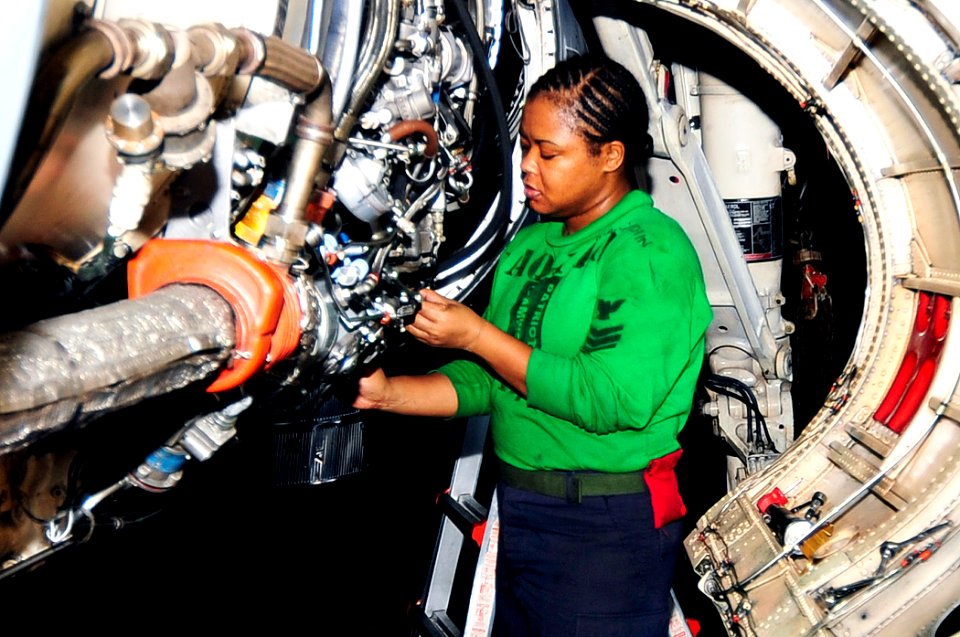 US Navy 100417-N-6935K-005 Aviation Machinist's Mate 1st Class Audrey Cutchin inspects the engine bay of an EA-6B Prowler
