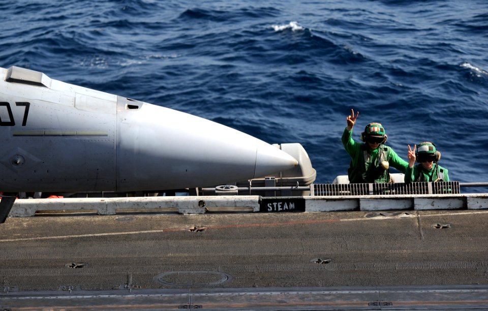 US Navy 100417-N-4236E-326 Sailors signal an F-A-18E Super Hornet assigned to the Pukin Dogs of Strike Fighter Squadron (VFA) 143 aboard the aircraft carrier USS Dwight D. Eisenhower (CVN 69)