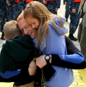 US Navy 100413-N-8467N-006 Machinist's Mate 1st Class Jason Fancher hugs his children moments after the attack submarine USS Virginia (SSN 774) returned to Submarine Base New London photo