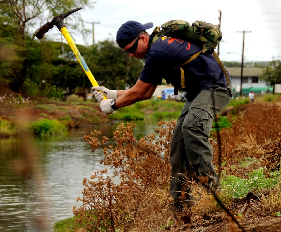 US Navy 100417-N-7498L-614 Master-at-Arms 2nd Class Ingellis Vincent, assigned to Joint Base Pearl Harbor-Hickam, clears weeds at the Kapakahi Stream