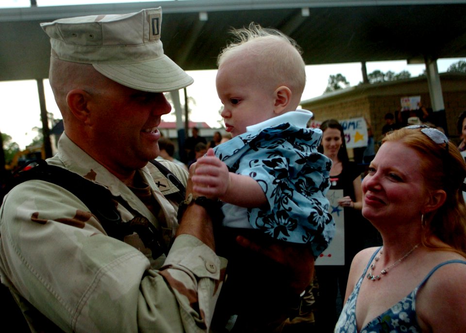 US Navy 100418-N-4440L-099 Lt. Gregory Hazlett is welcomed home by his wife and holds his son for the first time at Naval Construction Battalion Center, Gulfport