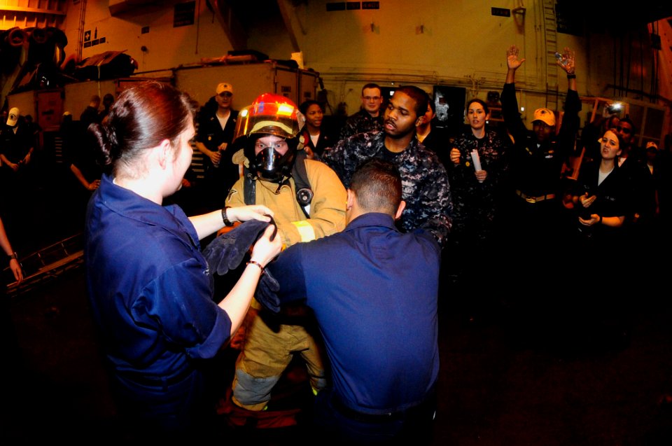 US Navy 100415-N-6604E-121 Sailors compete donning fire-fighting ensembles during the damage control Olympics aboard the aircraft carrier USS Dwight D. Eisenhower (CVN 69)