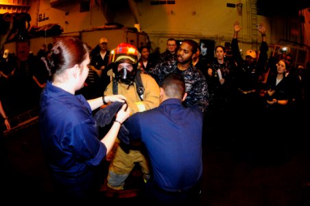 US Navy 100415-N-6604E-121 Sailors compete donning fire-fighting ensembles during the damage control Olympics aboard the aircraft carrier USS Dwight D. Eisenhower (CVN 69)