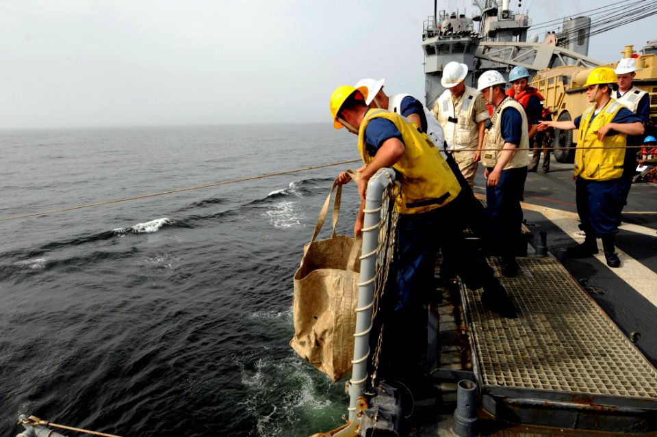 US Navy 100419-N-6676S-010 Sailors aboard the amphibious dock landing ship USS Gunston Hall (LSD 44) lower a satchel connected to a heaving line for transfer during a connected replenishment