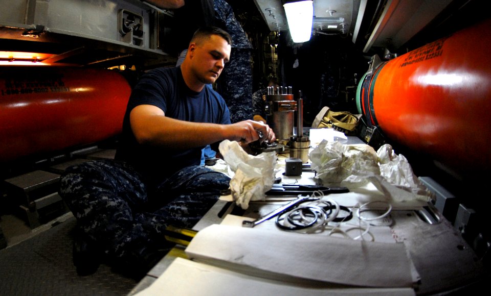 US Navy 100414-N-7705S-024 Machinist's Mate 2nd Class Rick Mason, from Vancouver, Wash., performs maintenance on a VLS locking bar cylinder aboard the Los Angeles-class attack submarine USS Newport News (SSN 750)