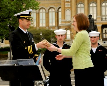 US Navy 100421-N-2389S-022 Cmdr. Justin Shineman, commanding officer for Navy Recruiting District Minneapolis, gives a modern cannon shell to a representative of the governor of Des Moines as a thank you from the Navy during De