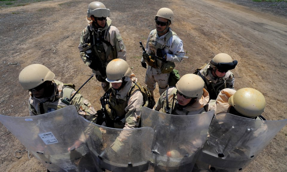 US Navy 100421-N-4965F-369 Sailors assigned to Maritime Expeditionary Security Squadron (MSRON) 3 take cover behind riot shields