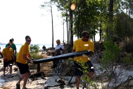 US Navy 100421-N-6936D-018 Boatswain's Mate 2nd Class Nicholas Matteson, left, and Operations Specialist 1st Class Roger Wilkerson remove fallen timber from the beach photo