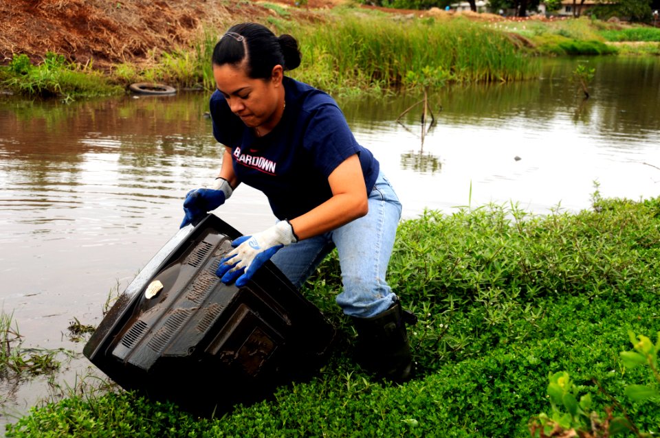US Navy 100417-N-7498L-911 Information Systems Technician 2nd Class Bri Gamiao, assigned to the guided-missile destroyer USS O'Kane (DDG 77), dredges up a television from the Kapakahi Stream