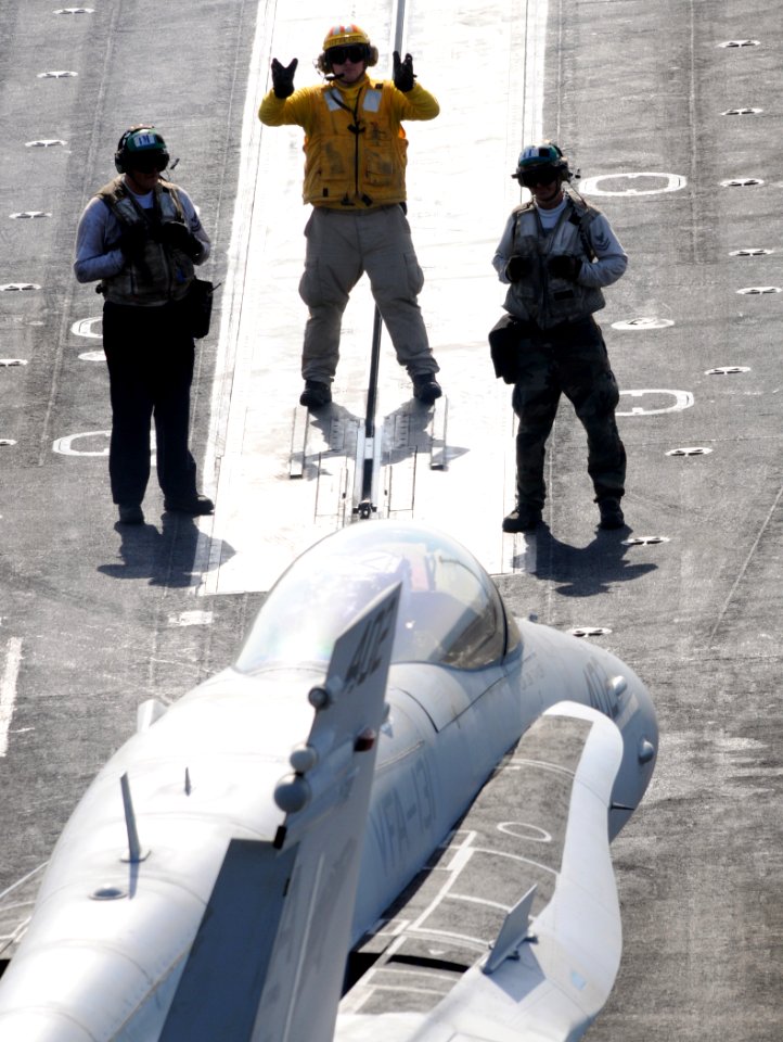 US Navy 100417-N-4236E-346 A Sailor directs an F-A-18C Hornet assigned to the Wildcats of Strike Fighter Squadron (VFA) 131 aboard the aircraft carrier USS Dwight D. Eisenhower (CVN 69)