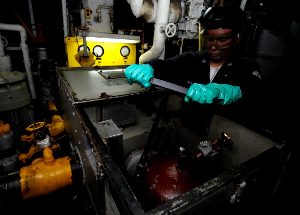 US Navy 100417-N-7948R-026 Machinist's Mate 3rd Class Boris Barrantes opens a main engine strainer to inspect debris aboard the amphibious assault ship USS Peleliu (LHA 5)