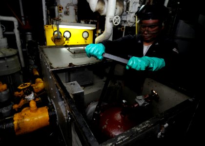 US Navy 100417-N-7948R-026 Machinist's Mate 3rd Class Boris Barrantes opens a main engine strainer to inspect debris aboard the amphibious assault ship USS Peleliu (LHA 5)