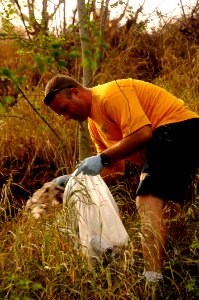 US Navy 100422-N-7498L-247 Chief Boatswain's Mate Todd Demers picks up trash at Rainbow Bay Marina