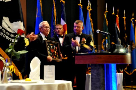 US Navy 100417-N-2200C-002 Jim Rothermel, a retired Navy Painter 1st Class, is awarded a Combat Action Ribbon and is presented a shadowbox of items representing his service with Naval Mobile Construction Battalion (NMCB) 14