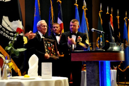 US Navy 100417-N-2200C-002 Jim Rothermel, a retired Navy Painter 1st Class, is awarded a Combat Action Ribbon and is presented a shadowbox of items representing his service with Naval Mobile Construction Battalion (NMCB) 14 photo