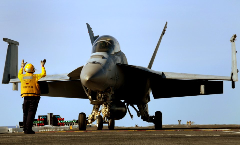 US Navy 100420-N-8913A-289 A Sailor assigned to the air department of the aircraft carrier USS George H.W. Bush (CVN 77) directs an F-A-18F Super Hornet