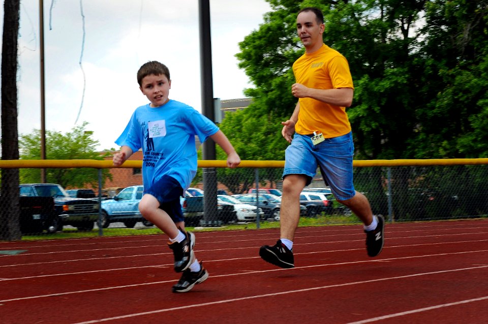 US Navy 100421-N-1522S-004 Logistic Specialist 2nd Class William Hoffman runs with a Special Olympics participant at the 14th annual Georgia Area 16 Special Olympics at Naval Submarine Base Kings Bay