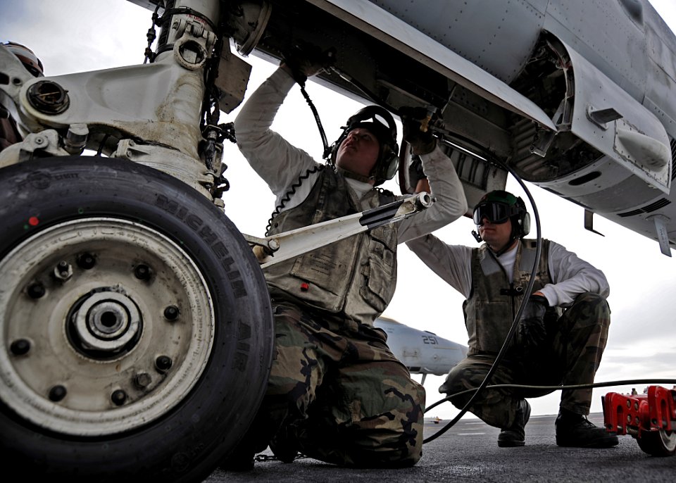 US Navy 100421-N-3885H-105 Aviation Structural Mechanics 2nd Class Matt Pinson, left, and Mark Albrecht, assigned to Strike Fighter Squadron (VFA) 106, perform maintenance on an F-A-18C Hornet aboard the aircraft carrier USS Ge