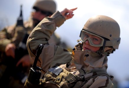 US Navy 100421-N-4965F-110 Master-at-Arms 3rd Class Alyson Mills, assigned to Maritime Expeditionary Security Squadron (MSRON) 3, signals to security watch standers on a simulated forward operating base during a Navy Expedition photo