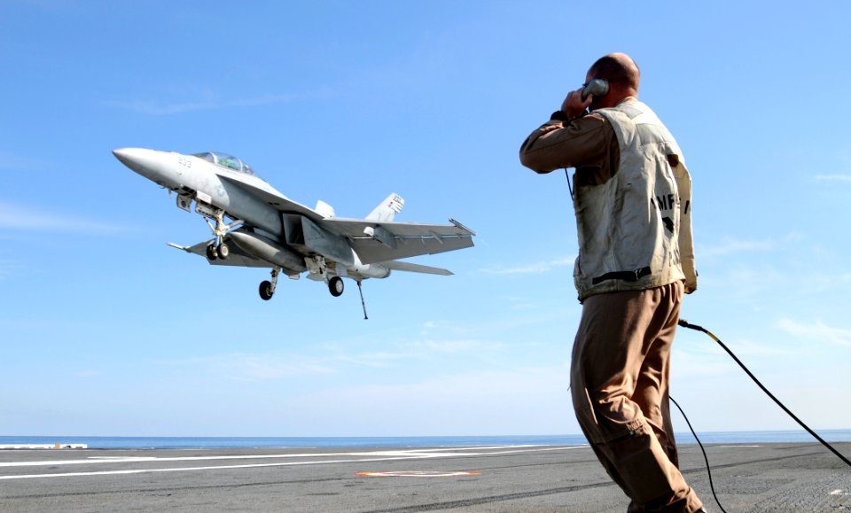 US Navy 100420-N-8913A-224 A landing signal officer communicates with the pilot of an F-A-18F Super Hornet as it lands on the flight deck of the aircraft carrier USS George H.W. Bush (CVN 77)