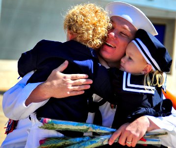 US Navy 100423-N-4774B-184 A Sailor assigned to the littoral combat ship USS Freedom (LCS 1) greets his children during a homecoming celebration after the ship's maiden deployment photo