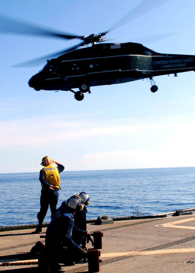 US Navy 100423-N-7478G-153 Seaman Drew Iverson salutes the pilot of an SH-60F Sea Hawk helicopter after launching from USS Blue Ridge (LCC 19)
