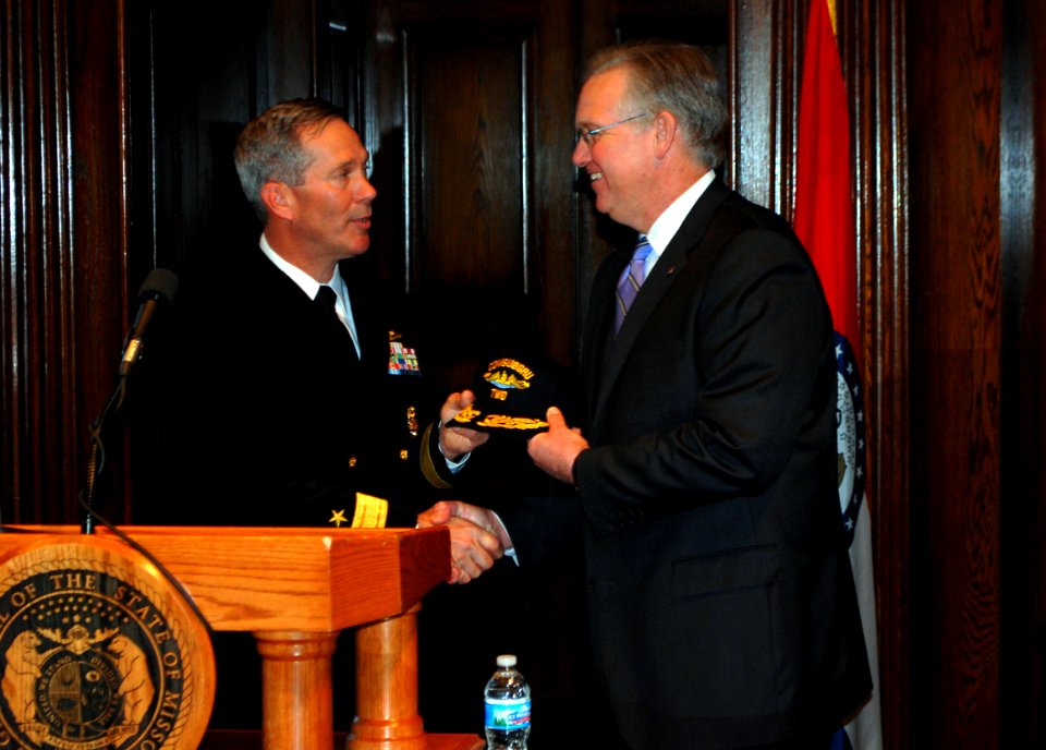 US Navy 100423-N-8750E-155 Rear Adm. Michael McLaughlin presents a group ball cap to Missouri Gov. Jay Nixon during a news conference