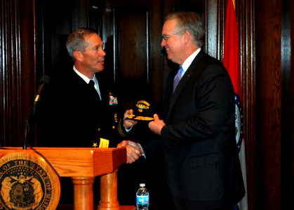 US Navy 100423-N-8750E-155 Rear Adm. Michael McLaughlin presents a group ball cap to Missouri Gov. Jay Nixon during a news conference