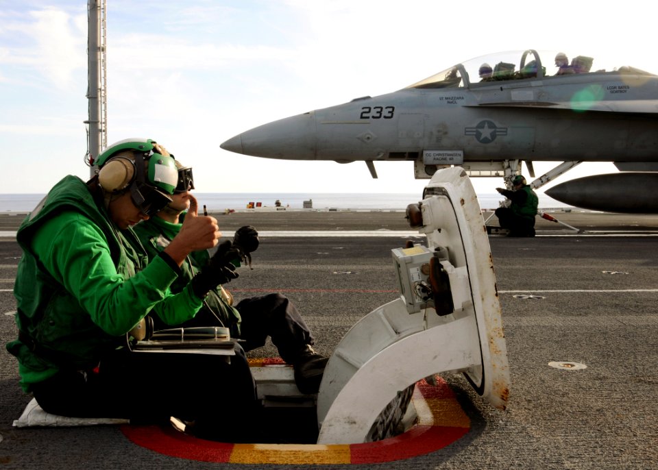 US Navy 100420-N-6509M-123 Sailors assigned to the air department of the aircraft carrier USS George H.W. Bush (CVN 77) direct an F-A-18 Hornet on the ship's flight deck