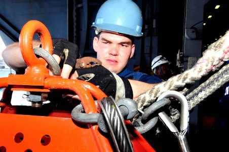 US Navy 100421-N-6935K-002 Boatswain's Mate 3rd Class Nicholas Circle works on the rigging of a transfer chair before sending it across to the Military Sealift Command fast combat support ship USNS Supply (T-AOE 6) during a rep