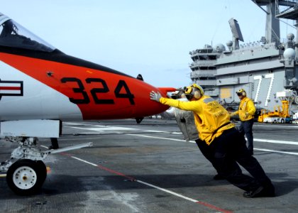 US Navy 100424-N-6509M-199 Sailors assigned to the aircraft carrier USS George H.W. Bush (CVN 77) push a T-45C Goshawk training aircraft assigned to Carrier Training Wing (CTW) 2 on the ship's flight deck