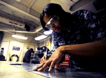 US Navy 100421-N-6003P-136 Aviation Structural Mechanic Airman Marisa Carter, from Detroit, Mich., measures metal to perform maintenance on a door aboard the Nimitz-class aircraft carrier USS Harry S. Truman (CVN 75)