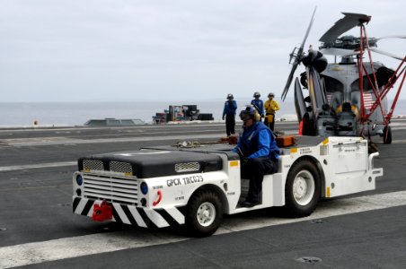 US Navy 100424-N-2821G-004 A tractor driver pulls a helicopter off the flight deck of the Nimitz-class aircraft carrier USS Abraham Lincoln (CVN 72) photo