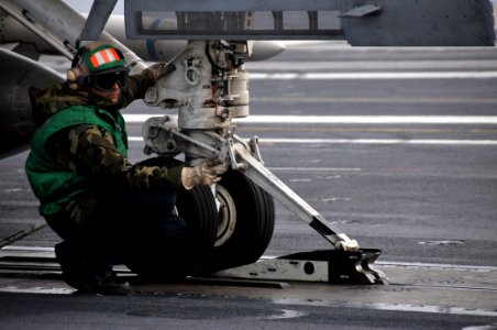 US Navy 100426-N-5749W-344 Aviation Boatswain's Mate (Equipment) 3rd Class Jesus Garcia, from Uvalde, Texas, guides an aircraft into the catapult shuttle aboard the aircraft carrier USS Abraham Lincoln (CVN 72)