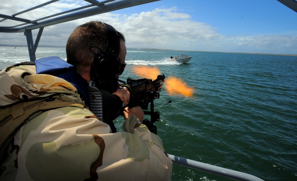 US Navy 100422-N-4965F-784 Boatswain's Mate 1st Class Jason Fuchs, a boat crewman gunner assigned to a boat detachment of Maritime Expeditionary Security Squadron (MSRON) 3, engages a simulated waterborne threat