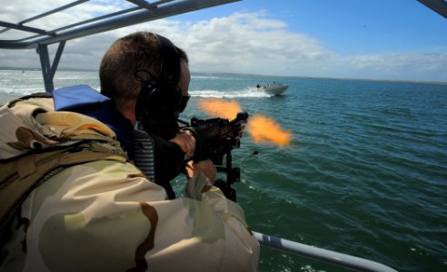 US Navy 100422-N-4965F-784 Boatswain's Mate 1st Class Jason Fuchs, a boat crewman gunner assigned to a boat detachment of Maritime Expeditionary Security Squadron (MSRON) 3, engages a simulated waterborne threat photo
